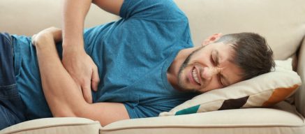 Man lying down with stomach pain, stomach bug