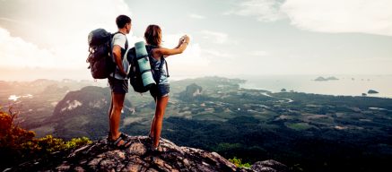 Man and woman taking a picture on top of a mountain