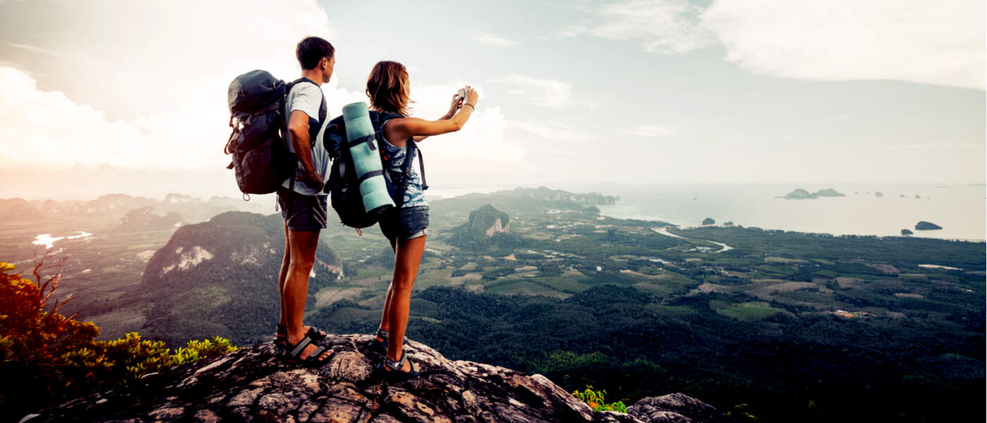 Man and woman taking a picture on top of a mountain