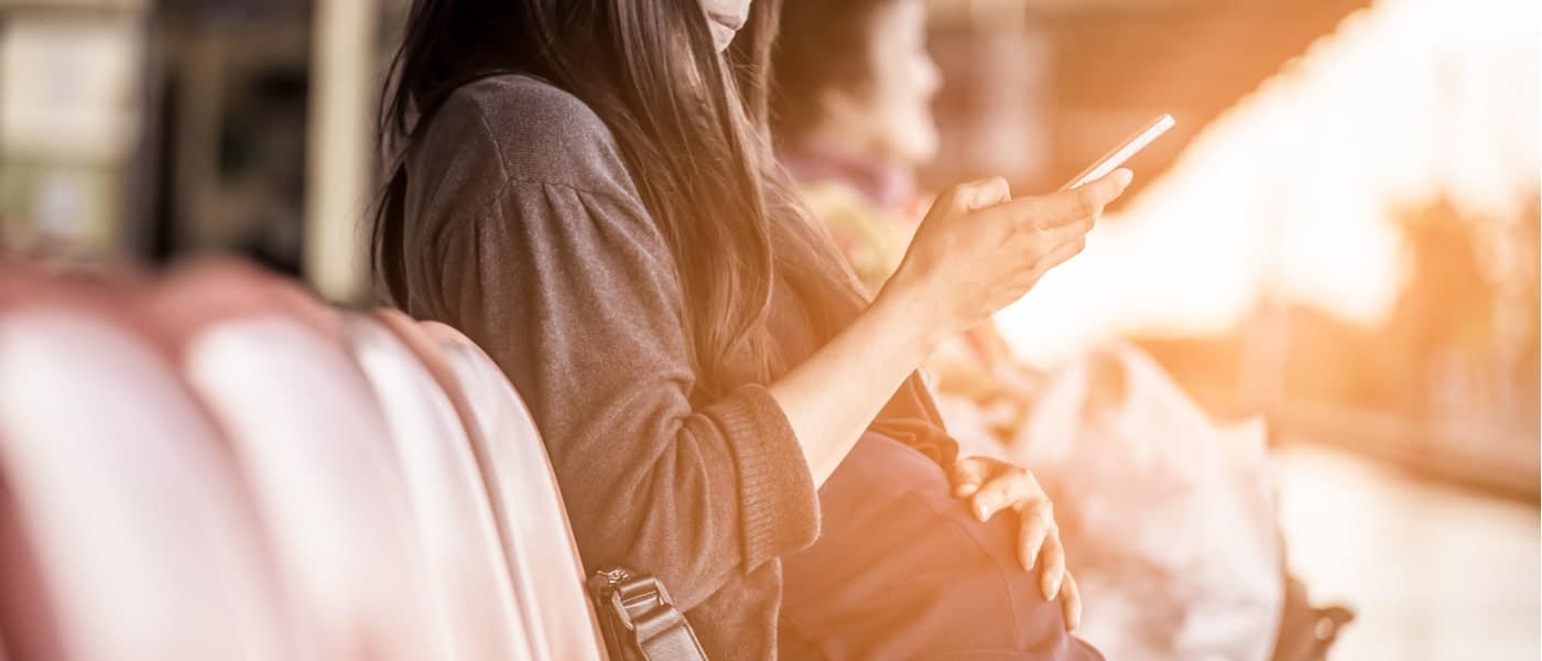 Pregnant woman sat down on her phone