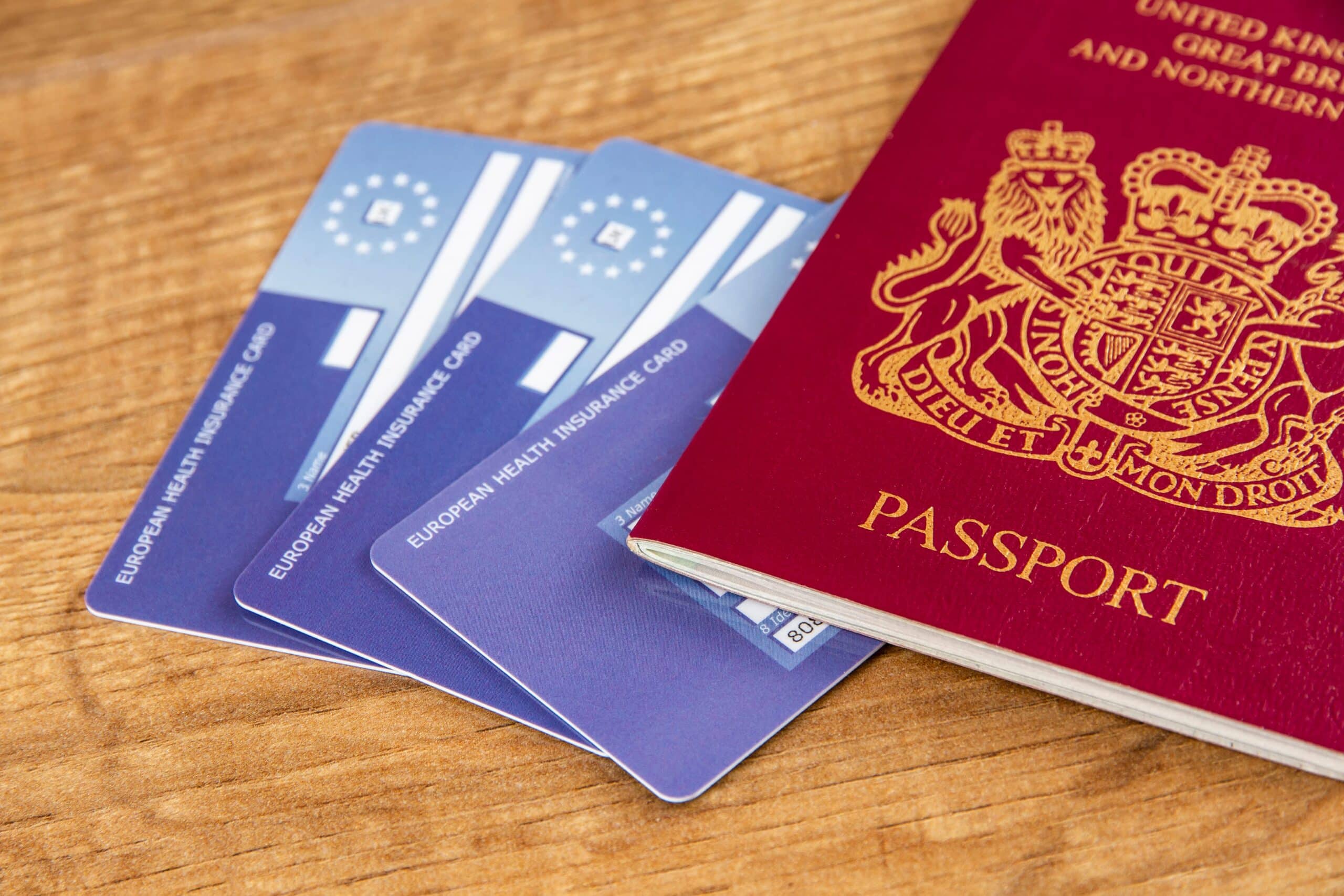 Passport and health insurance cards lying on wooden table