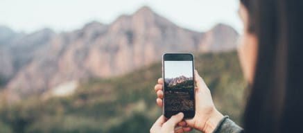 Woman taking a photo of some mountains