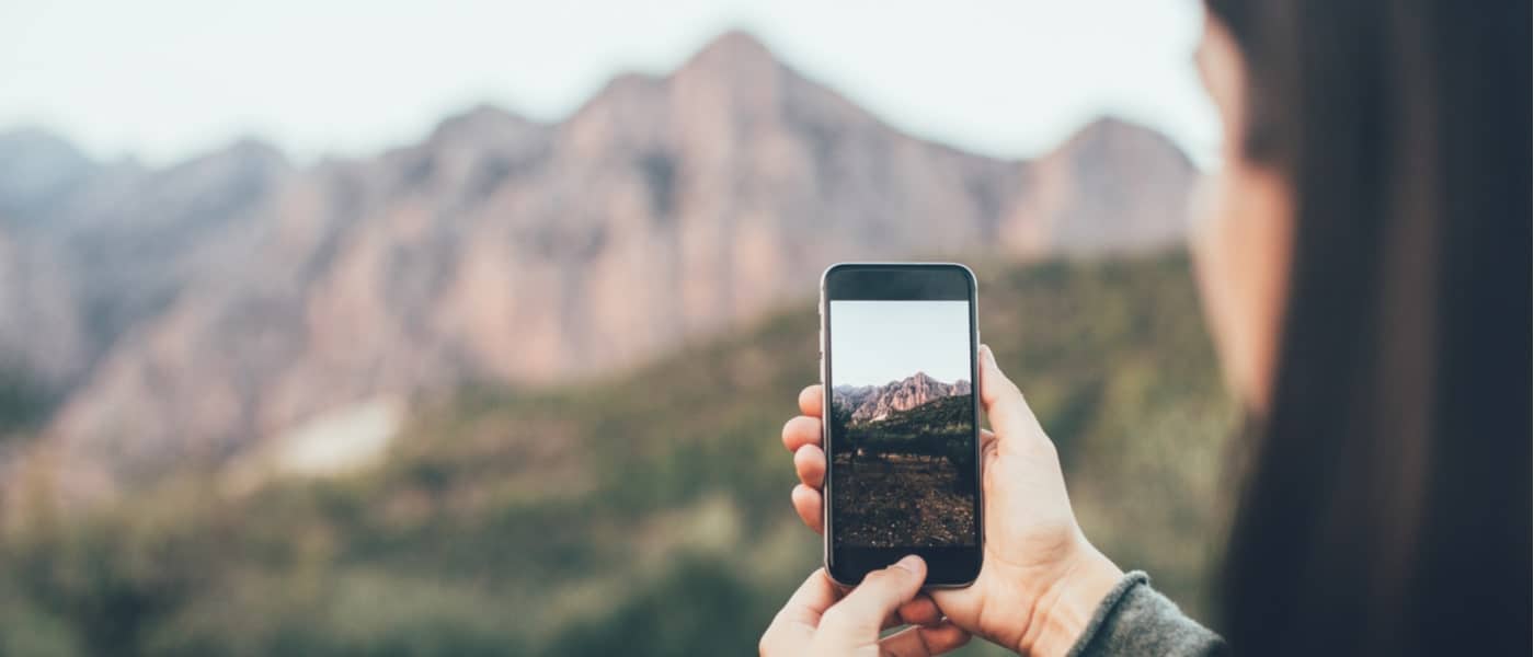 Woman taking a photo of some mountains