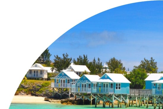 Huts on stilts in the sea in front of trees, Bermuda