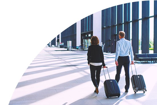 A man and a woman pulling suitcases