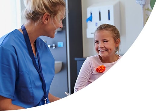 A nurse and a child smiling at each other