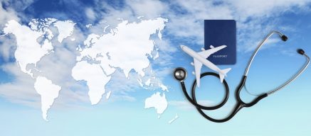 Map of the world with passport, model plane and stethoscope